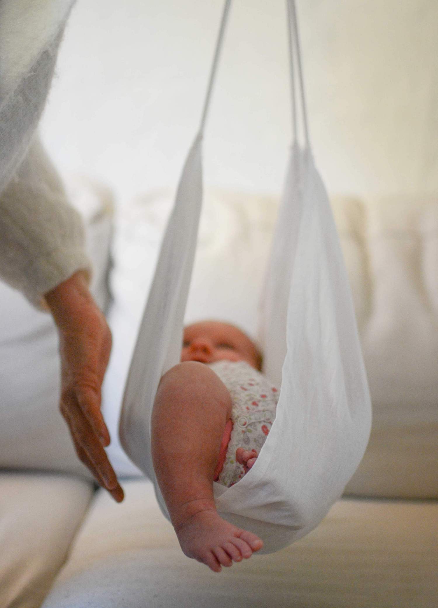 Pesée du bébé, accompagné dans un tissu